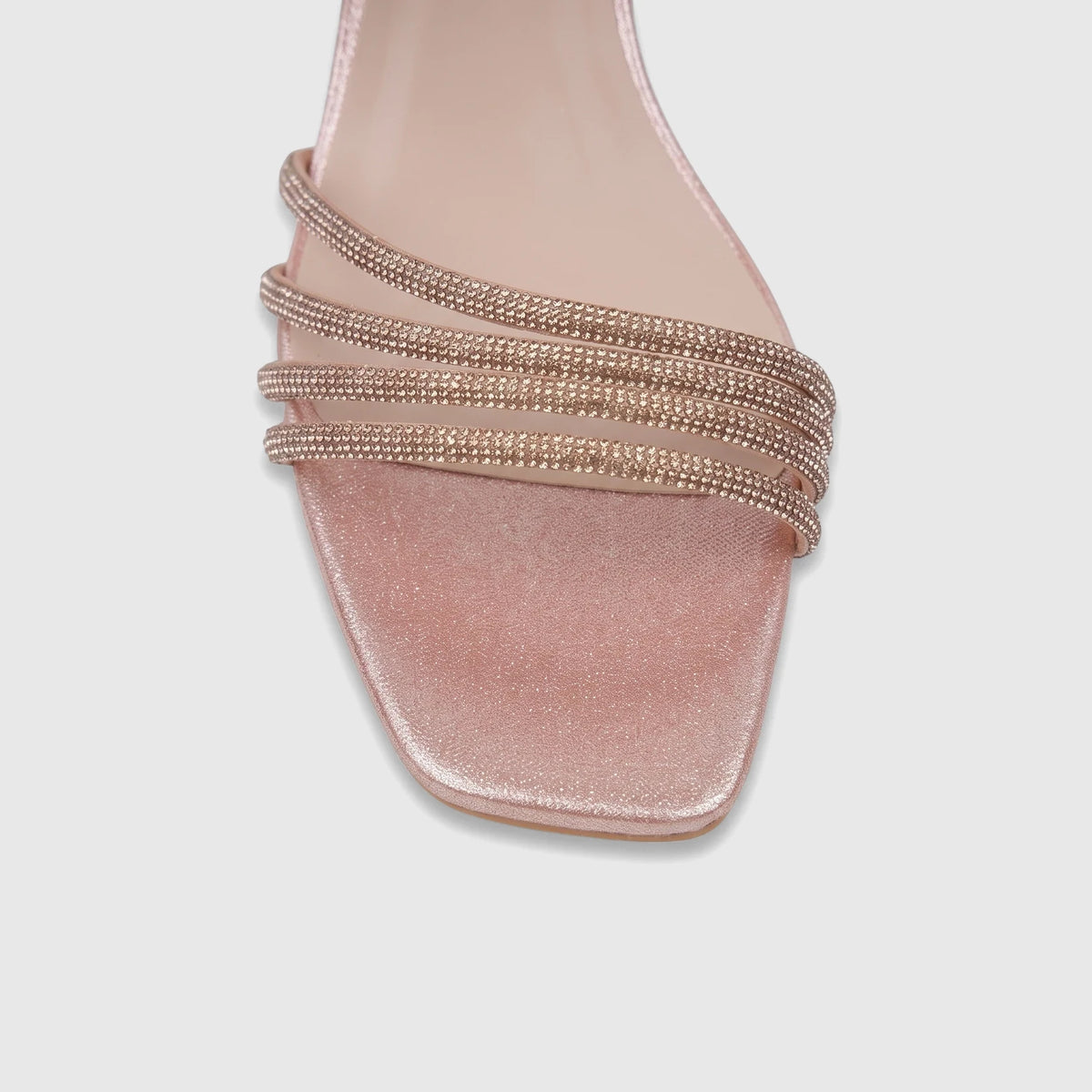 Close-up of a pink satin ladies evening block heel sandal featuring shimmering rhinestone straps across the vamp.