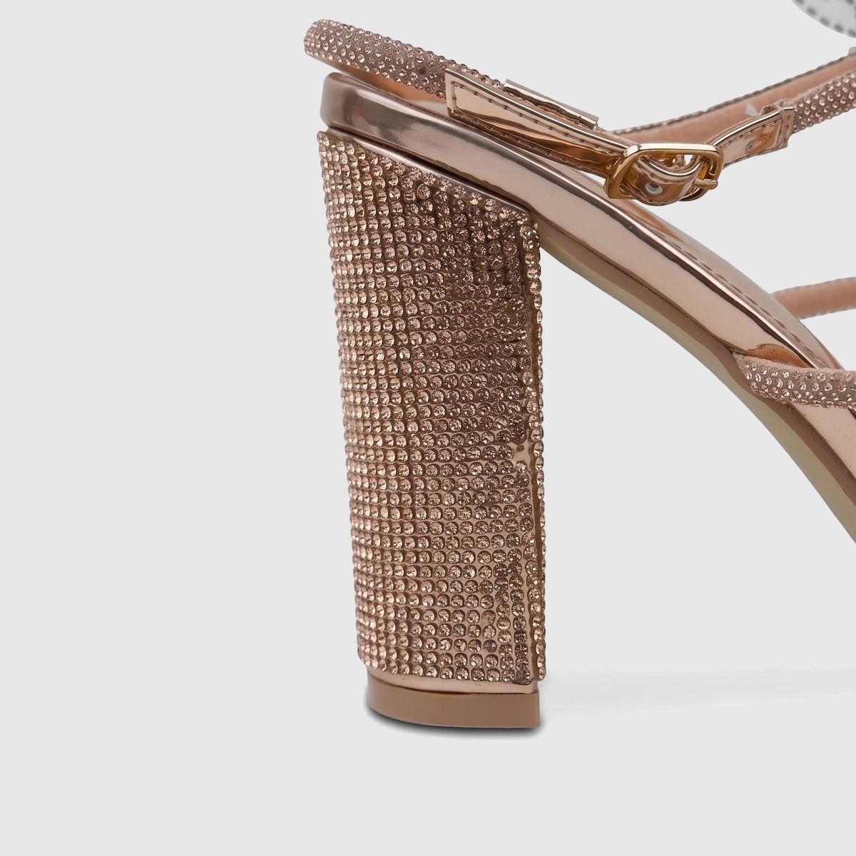 Close-up of a rose gold Bulbul Ladies Evening Block Heel Sandal with sparkling rhinestone-embellished block heel and straps.