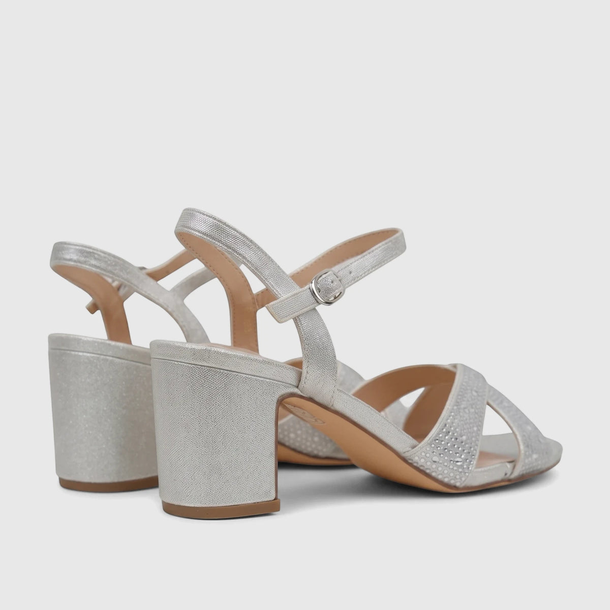 Silver glitter block heel sandals with rhinestone-embellished criss-cross straps, viewed from a low angle, suitable for