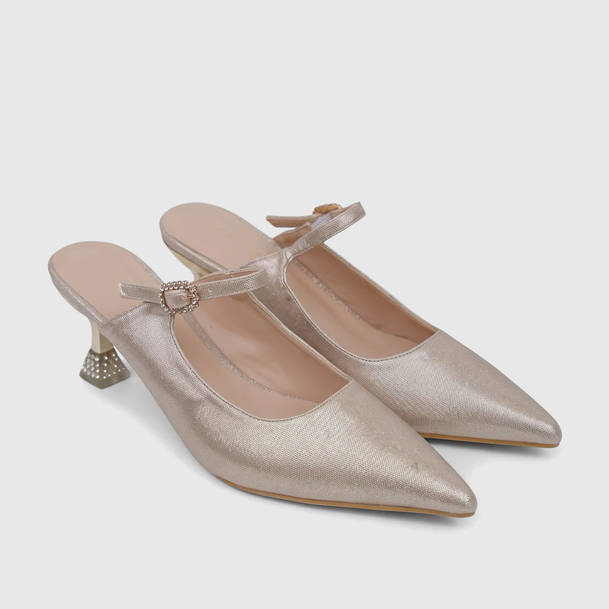 A pair of elegant gold shimmering ladies' evening open back court heels with pointed toes, rhinestone buckles, and bejeweled