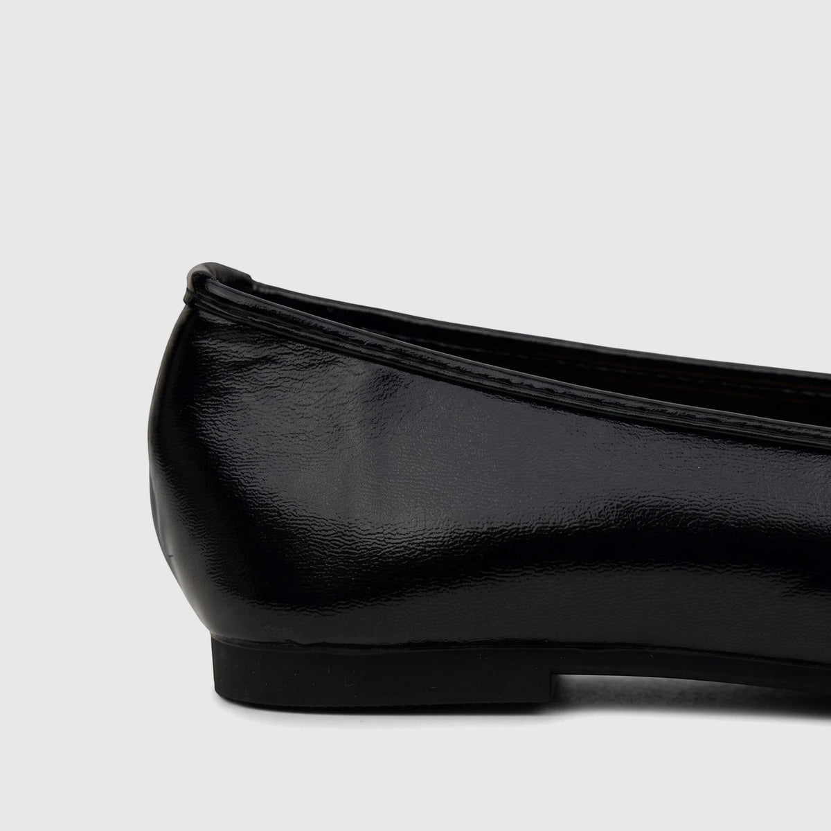 Side profile of a Bulbul Ladies Evening Pump in black patent leather, showcasing the glossy finish and low heel of the flat