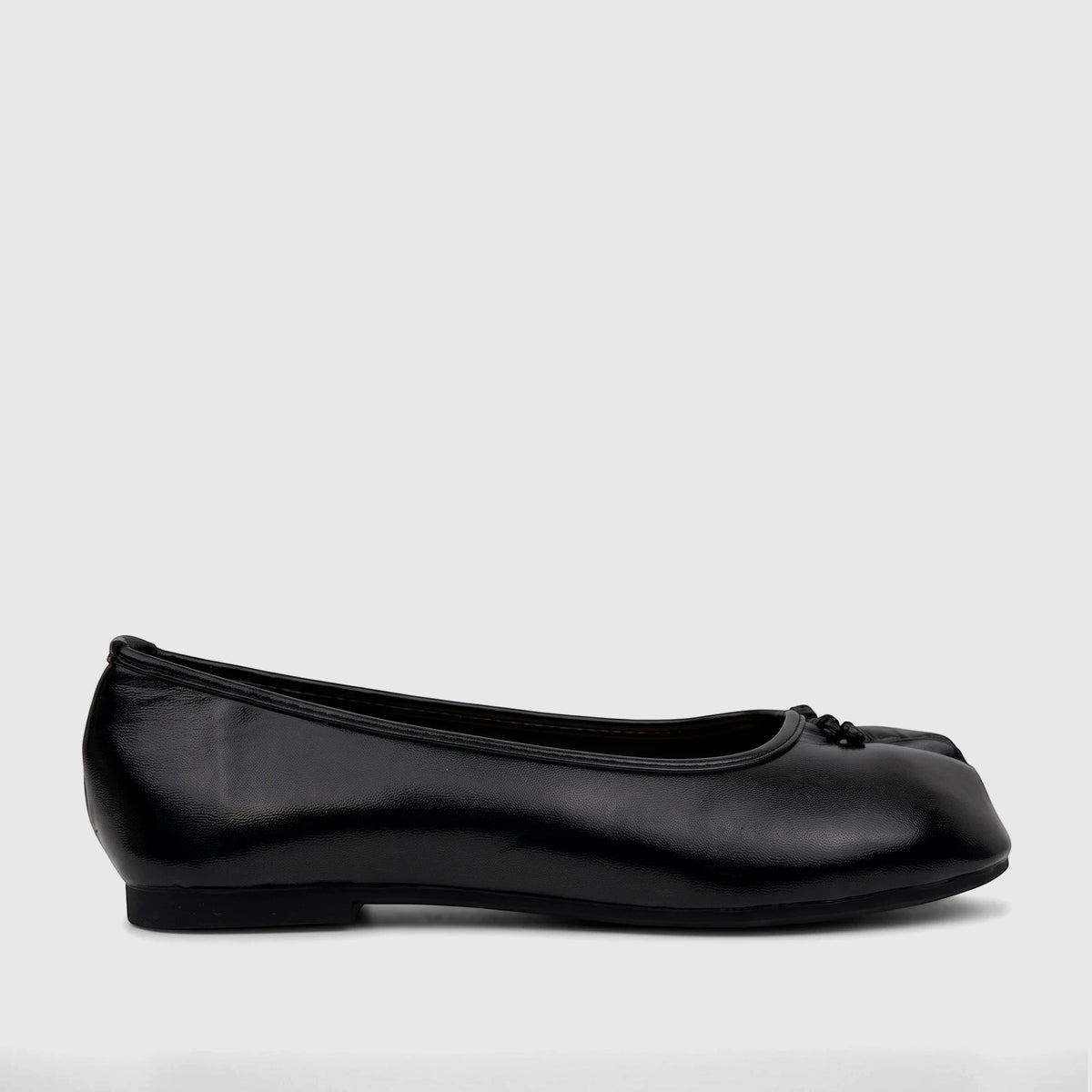 Bulbul Ladies Evening Pump in black patent-like finish, shown from the side with a small decorative bow.