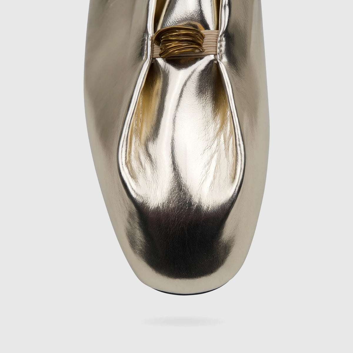 Close-up front view of a shiny light gold metallic Bulbul ladies' evening pump with a gathered vamp.
