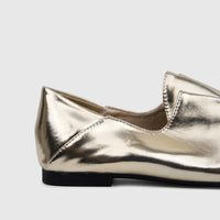 A close-up side view of a single Bulbul Ladies Evening Pump in light gold with a metallic finish and a black sole.