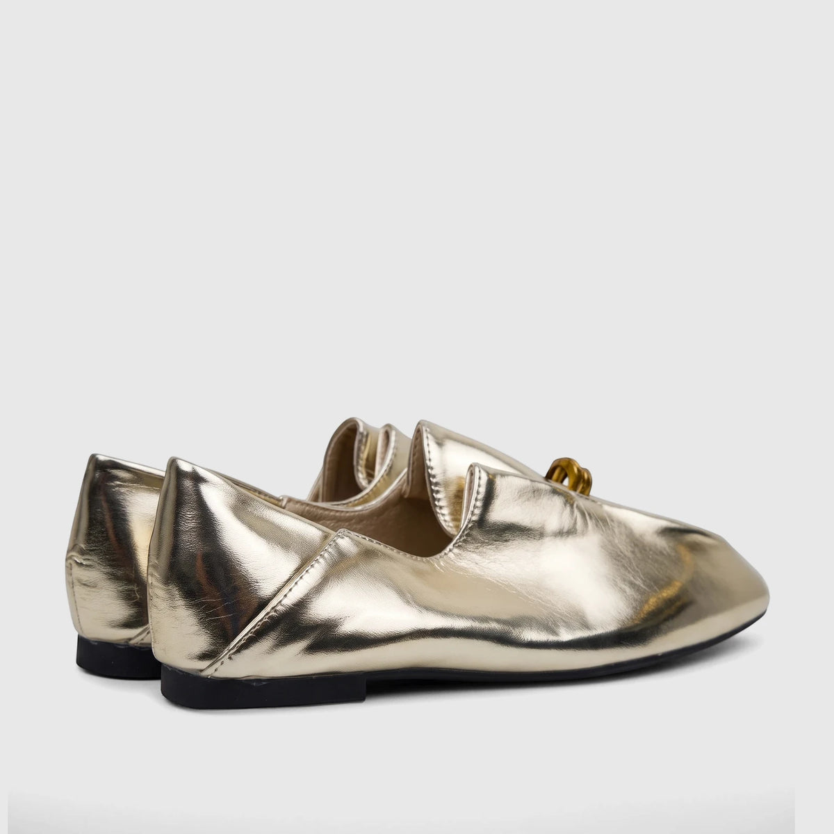 Pair of light gold metallic Bulbul Ladies Evening Pump flats with a pointed toe and black sole, viewed from the side.