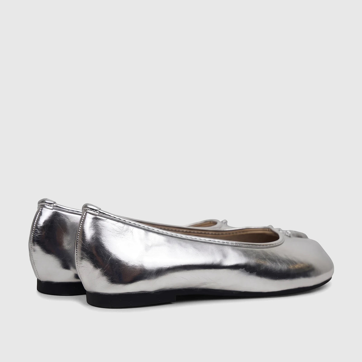 A pair of shiny silver metallic Bulbul Ladies Evening Pump ballet flats, shown from a slightly angled rear-side view.