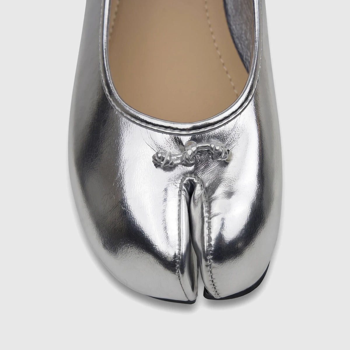 Close-up of a shiny silver Bulbul Ladies Evening Pump featuring a unique split-toe design and metallic embellishment.