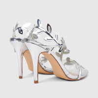 A pair of silver Bulbul Ladies Evening Sandals, featuring elegant leaf-shaped metallic straps and clear panels, showcased