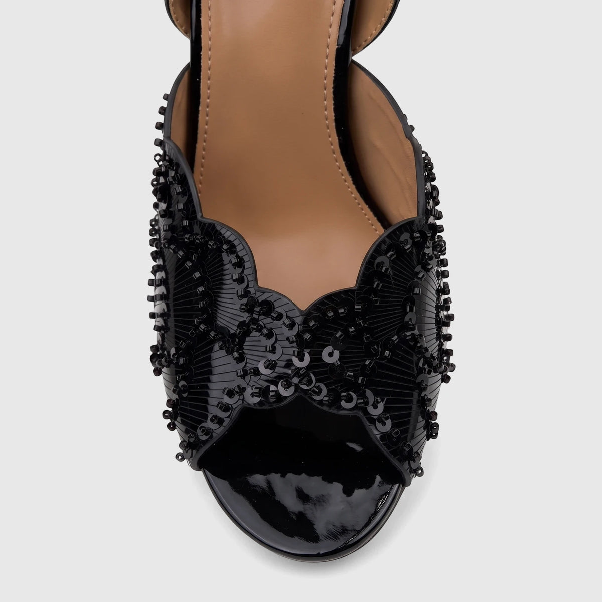 Close-up of a black sequined Bulbul Ladies Evening Slingback Sandal with a patent leather toe.