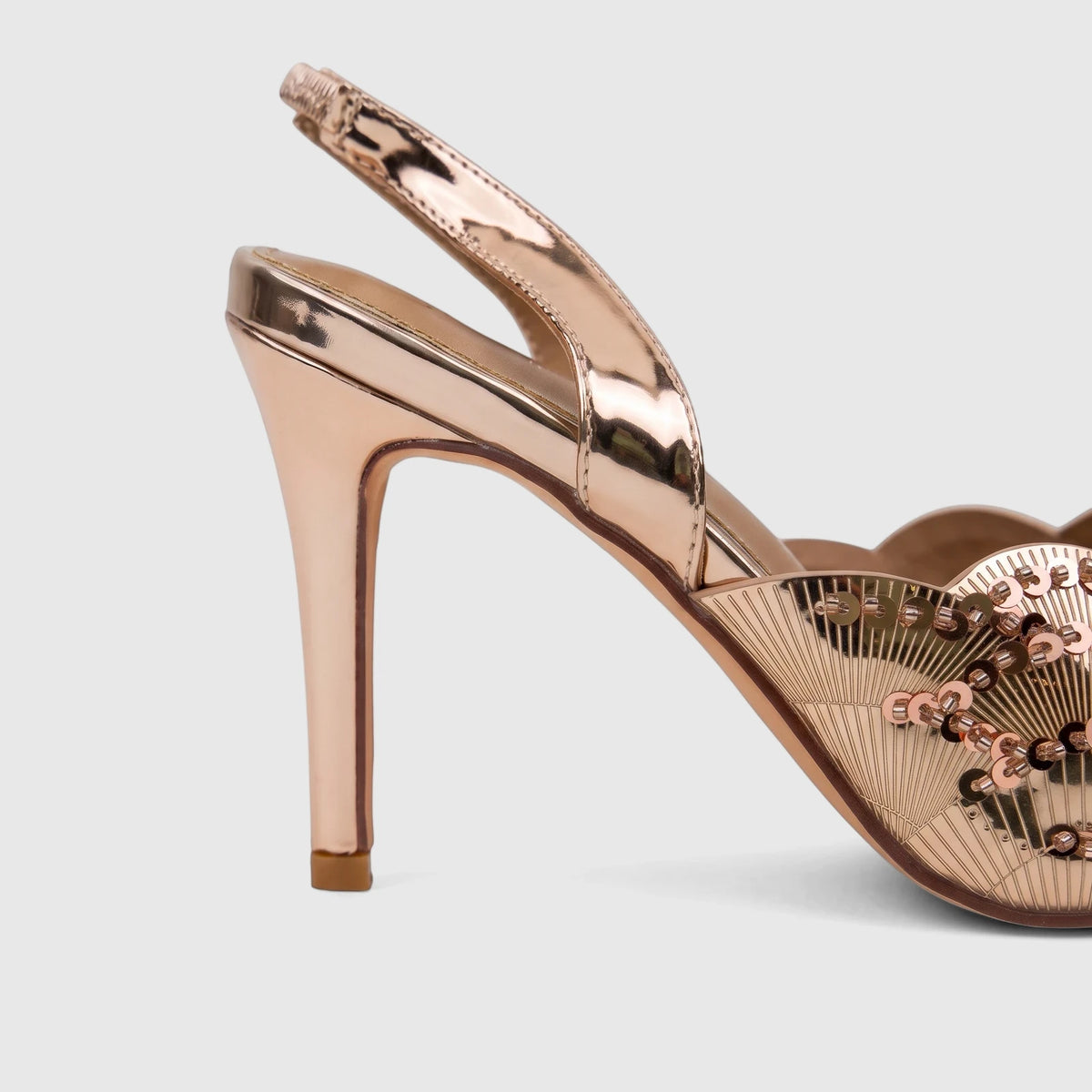Bulbul Ladies Evening Slingback Sandal Champagne HAR100. Close-up of a single rose gold metallic high-heeled slingback