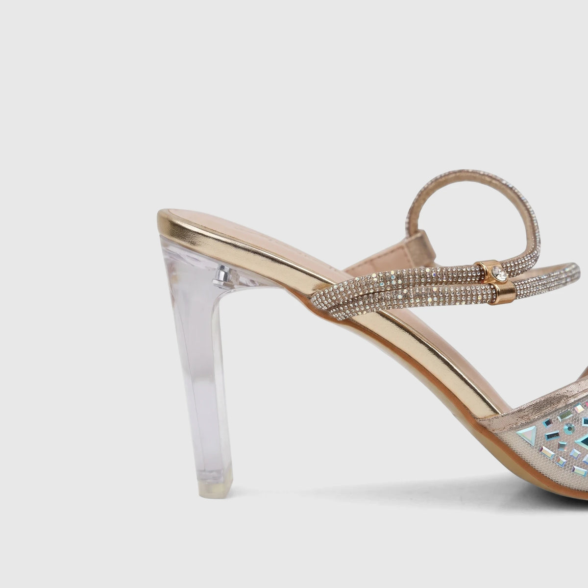 Gold Bulbul ladies evening slingback sandal with rhinestone-embellished straps and a clear block heel, side view.