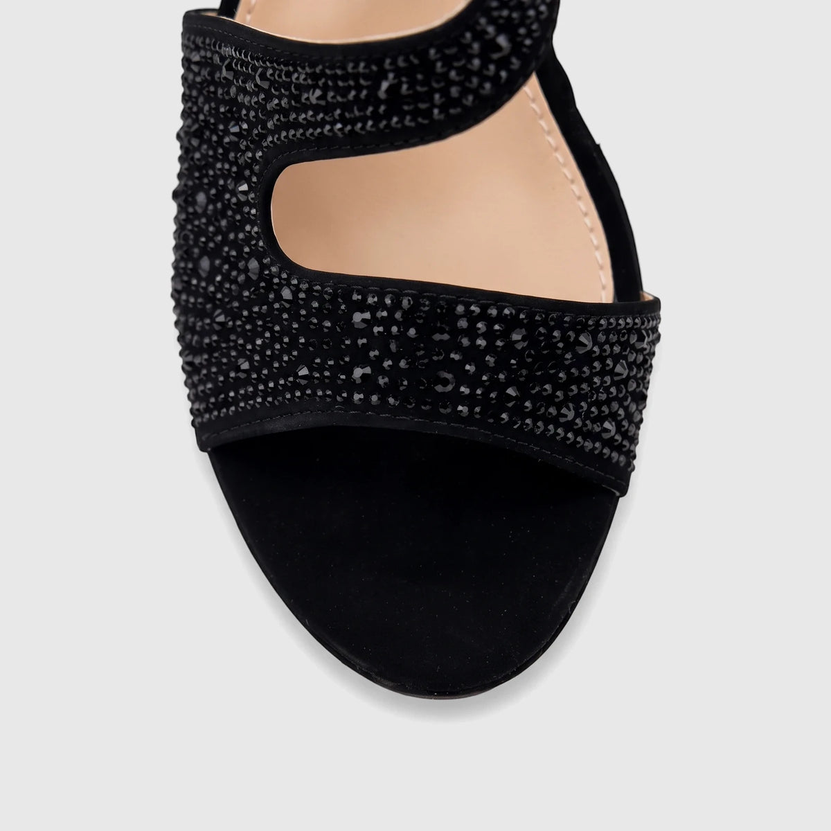 Close-up of a black embellished ladies evening wedge sandal, featuring a wide strap adorned with sparkling black rhinestones.