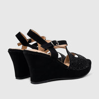 Black Bulbul Ladies Evening Wedge Sandals featuring sparkly embellished T-straps and high suede-like wedges, shown from a