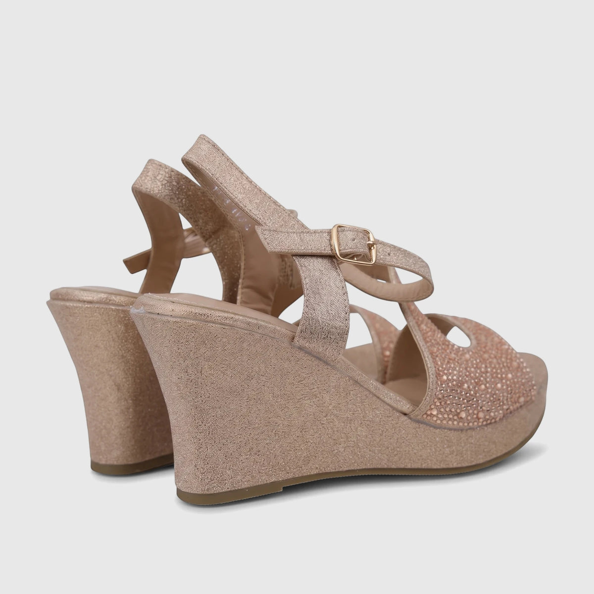 Pair of Bulbul Ladies Evening Wedge Sandals in champagne glitter with rhinestone embellishments and ankle straps, angled