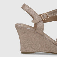 Champagne glitter women's wedge sandal with a gold buckle ankle strap and rhinestone embellishments on the front.
