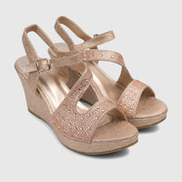 Pair of glittering champagne wedge sandals with rhinestone-embellished straps and an ankle buckle.