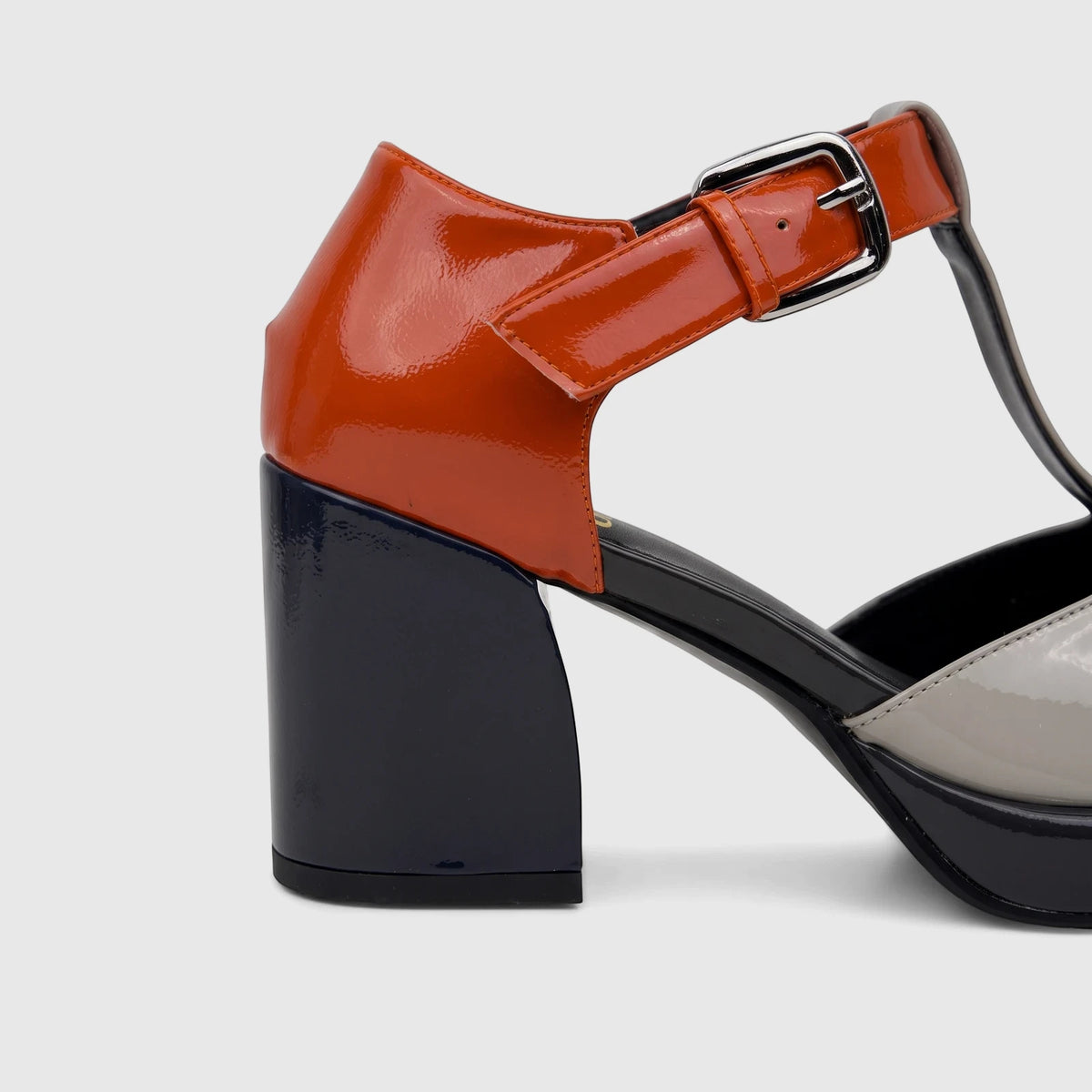Close-up of a Bulbul ladies' patent leather block heel shoe with a T-bar strap, featuring navy, orange, and grey colors.