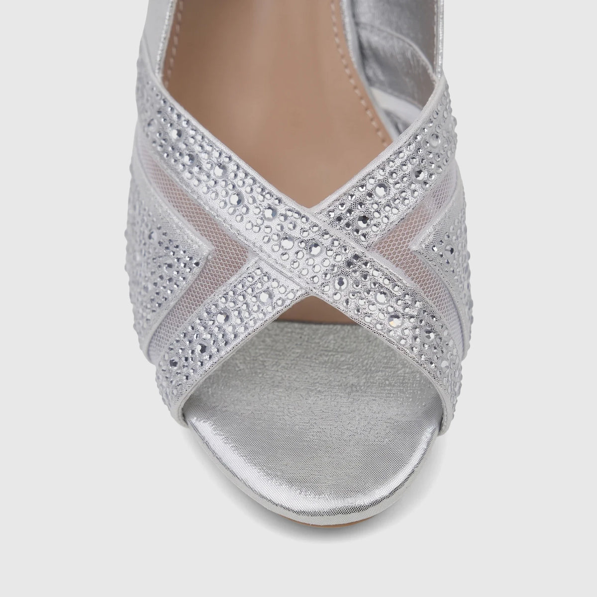 Close-up of a women's Bulbul silver evening wedge sandal with sparkling rhinestone criss-cross straps and a metallic finish.