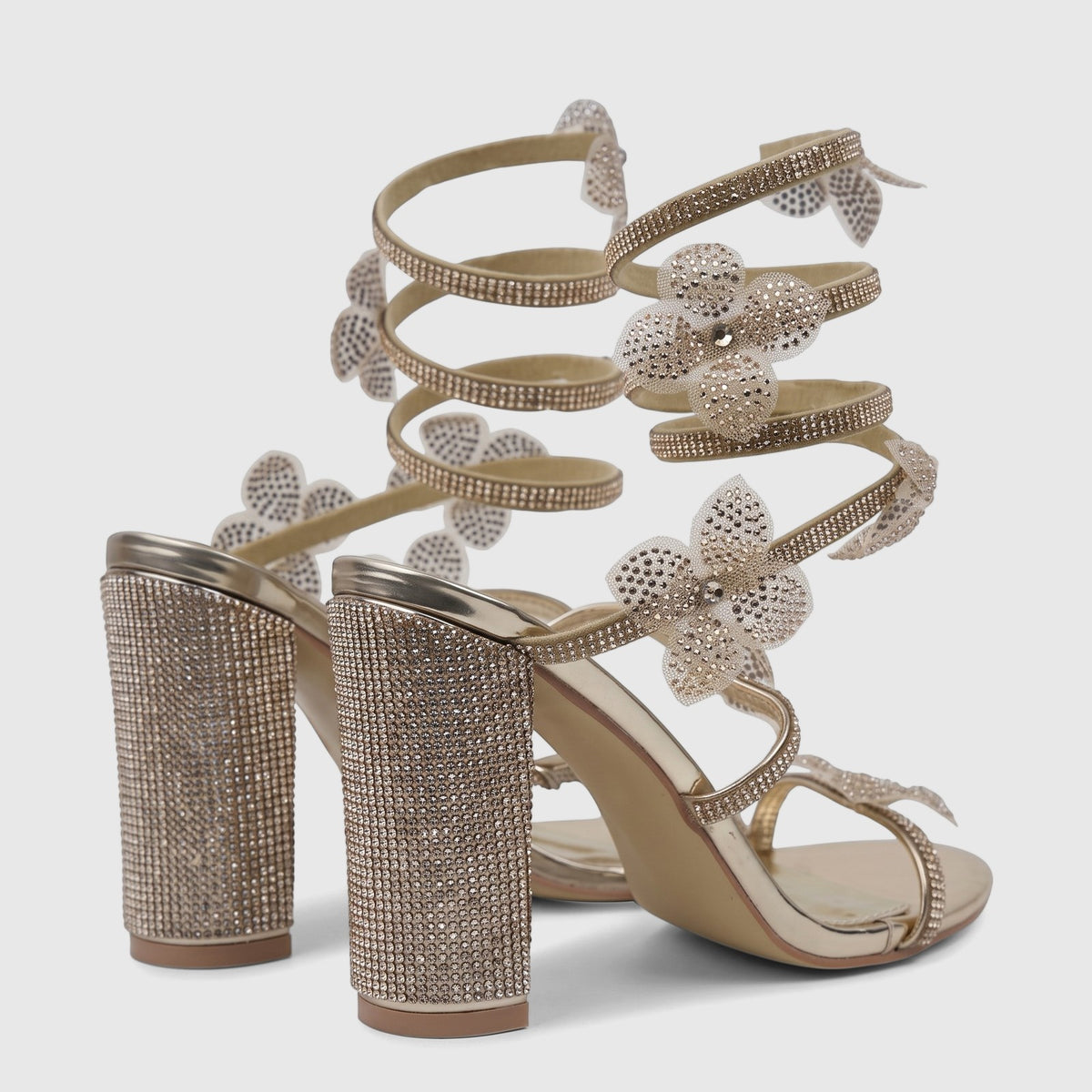 A pair of elegant gold Bulbul Ladies Spiral Strap Evening Heel Sandals, adorned with sparkling rhinestones and flower