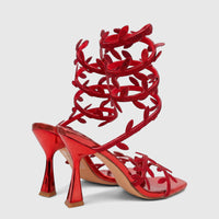A pair of red Bulbul Ladies Spiral Strap Evening Heel Sandals with sparkling rhinestones and a metallic finish.