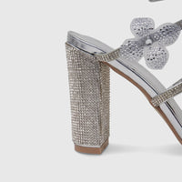 Close-up of a luxurious silver Bulbul Ladies Spiral Strap Evening Heel Sandal, featuring a rhinestone block heel.