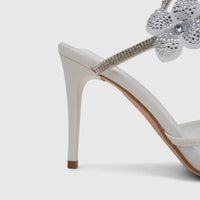 White Bulbul Ladies Spiral Strap Evening Heel Sandal with rhinestone flower embellishment, seen from a side view.
