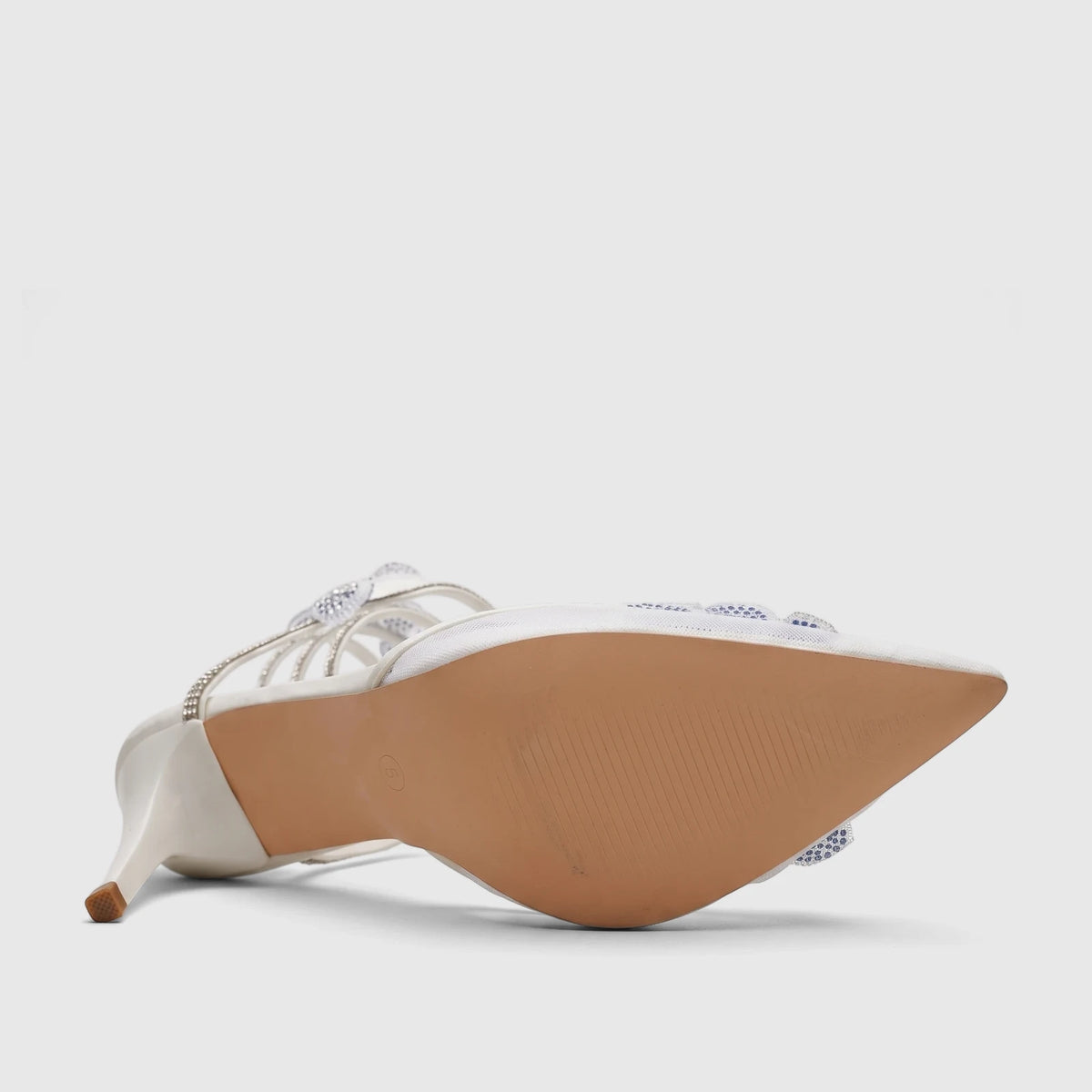 White Bulbul ladies' evening heel sandal with spiral rhinestone straps, shown from a low side angle with the sole visible.