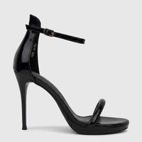 Bulbul Ladies Stiletto Heel Sandal in black patent leather with clear PVC straps and an ankle buckle, shown from the side.
