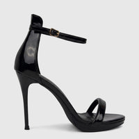 Black patent leather stiletto heel sandal with an ankle strap and gold buckle, shown in a close-up side view.