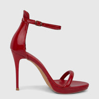Red patent leather stiletto heel sandal with clear ankle and toe straps and a gold buckle, shown from a side view.