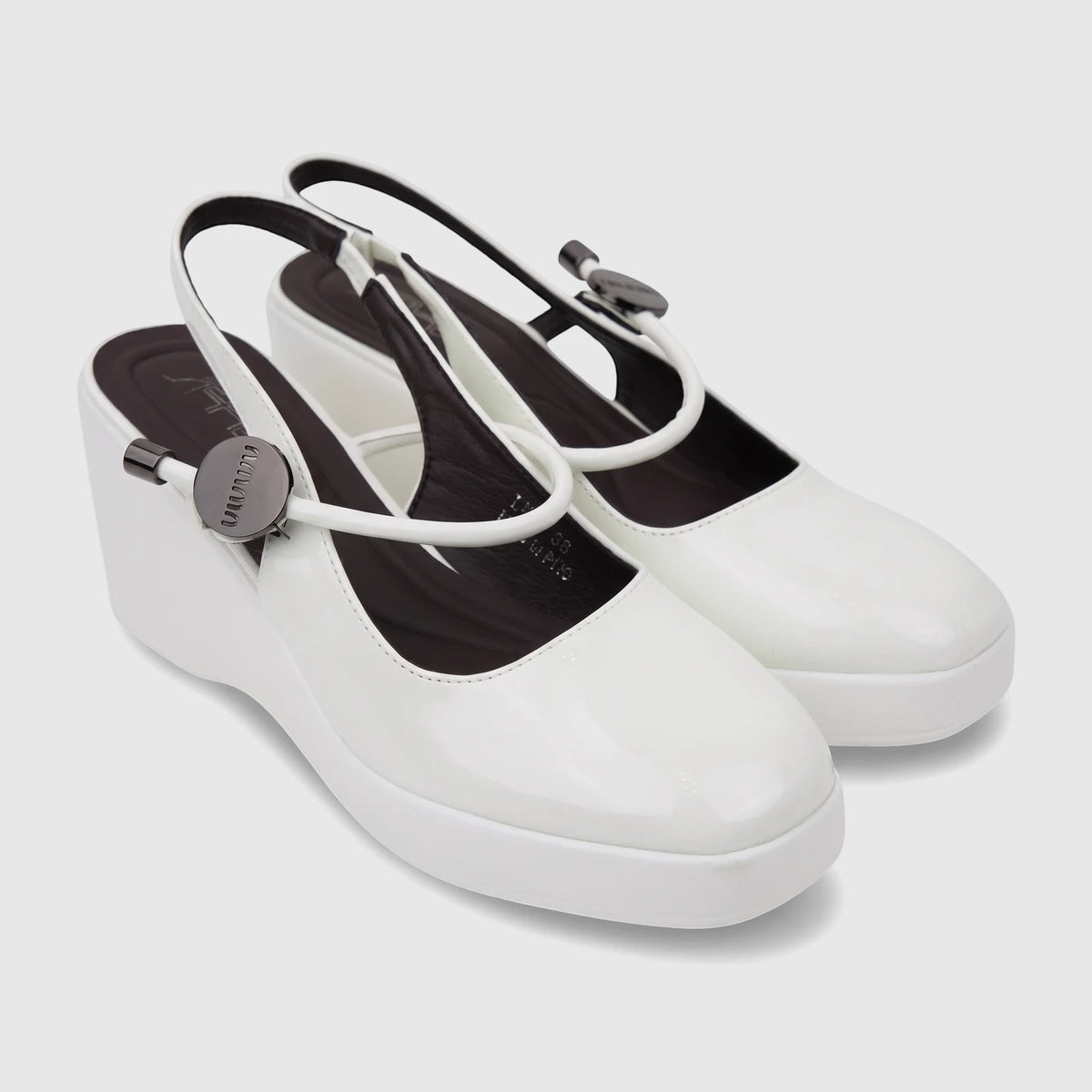 A pair of white patent leather Bulbul Ladies Dress Block Heel Sandals with slingback straps and black insoles, showcased