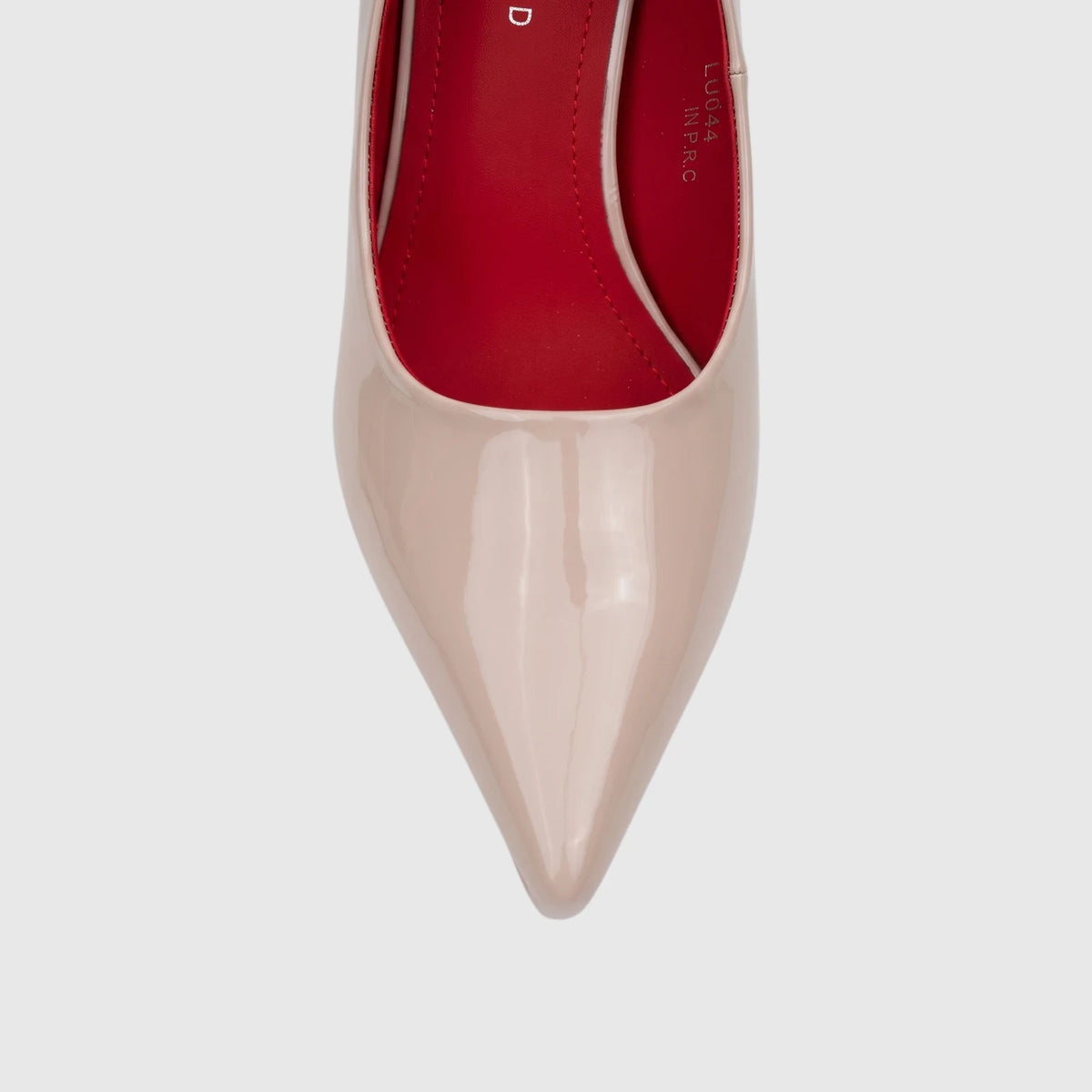 Close-up front view of a Bulbul nude patent leather pointed-toe dress court shoe with red interior lining.