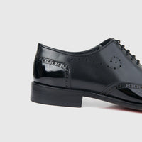 Bulletti men's black leather lace-up brogue dress shoe, side view showing glossy finish and perforated detailing.