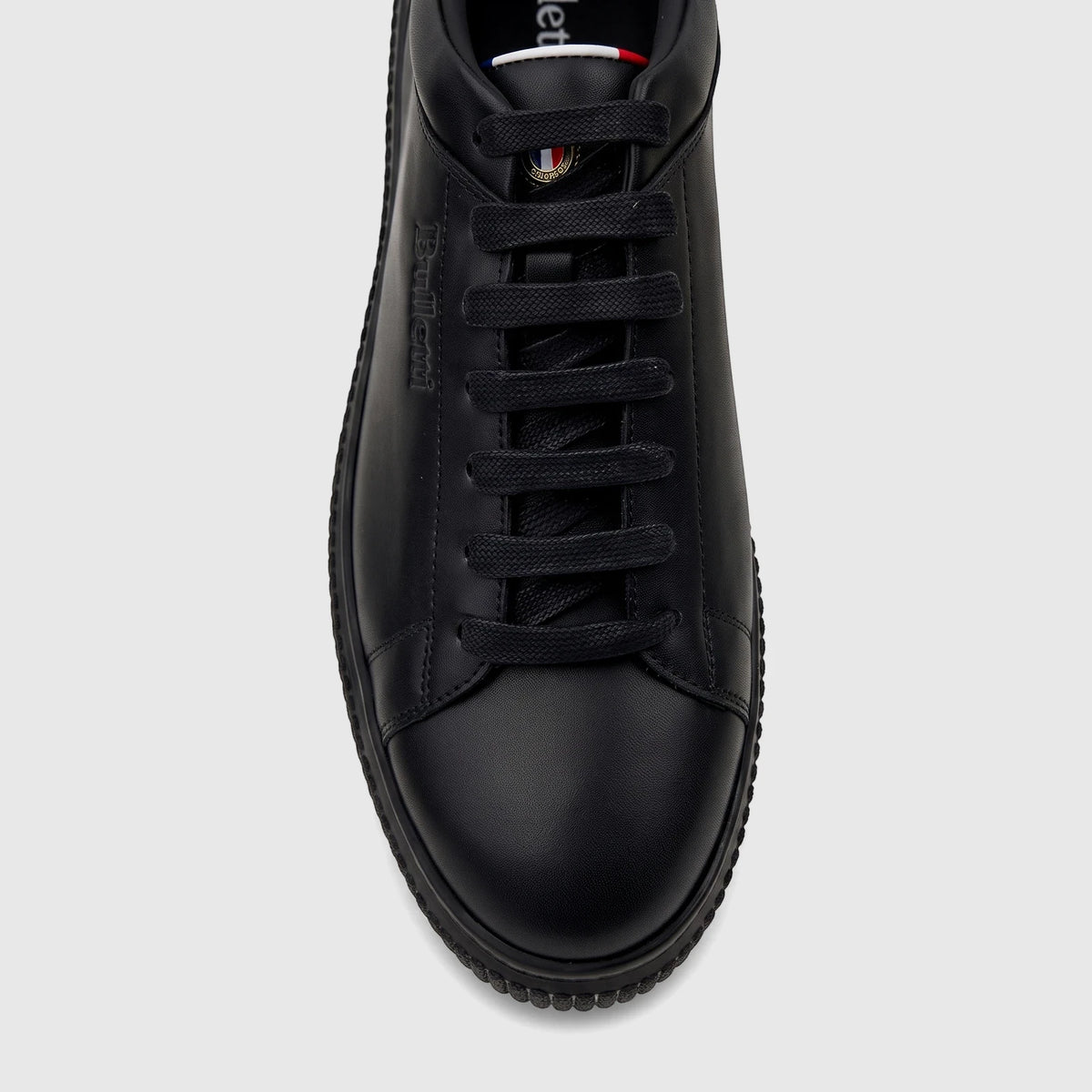 Close-up front view of a Bulletti Men's Black Leather Sneaker, featuring black laces and subtle branding on the side and