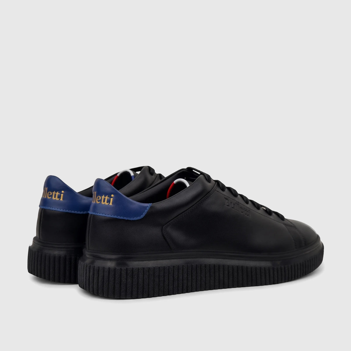 Bulletti Men's Black Leather Sneakers HASM-003 with blue heel tabs, gold lettering, and ridged soles, in a rear-side view.
