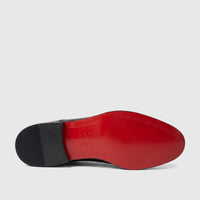 Bottom view of a Bulletti Men's black patent leather dress shoe with a vibrant red sole and a ribbed black heel.