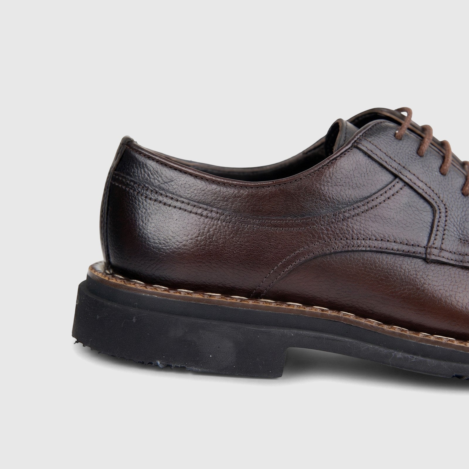 Close-up side view of a Bulletti Men's brown leather lace-up shoe with a chunky black sole and visible stitching details.