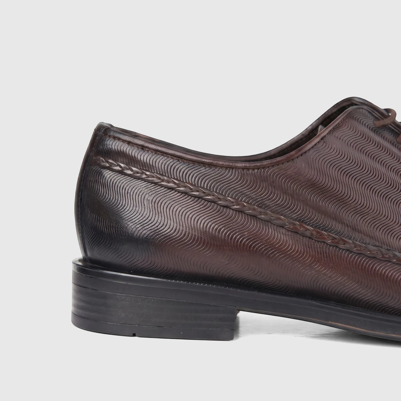 Bulletti Men's brown leather dress lace-up shoe, close-up of the side and heel, featuring unique wavy texture and braided