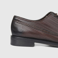 Side view of a Bulletti Men's Brown Leather Dress Lace Up Shoe featuring a distinctive wavy pattern and braided leather