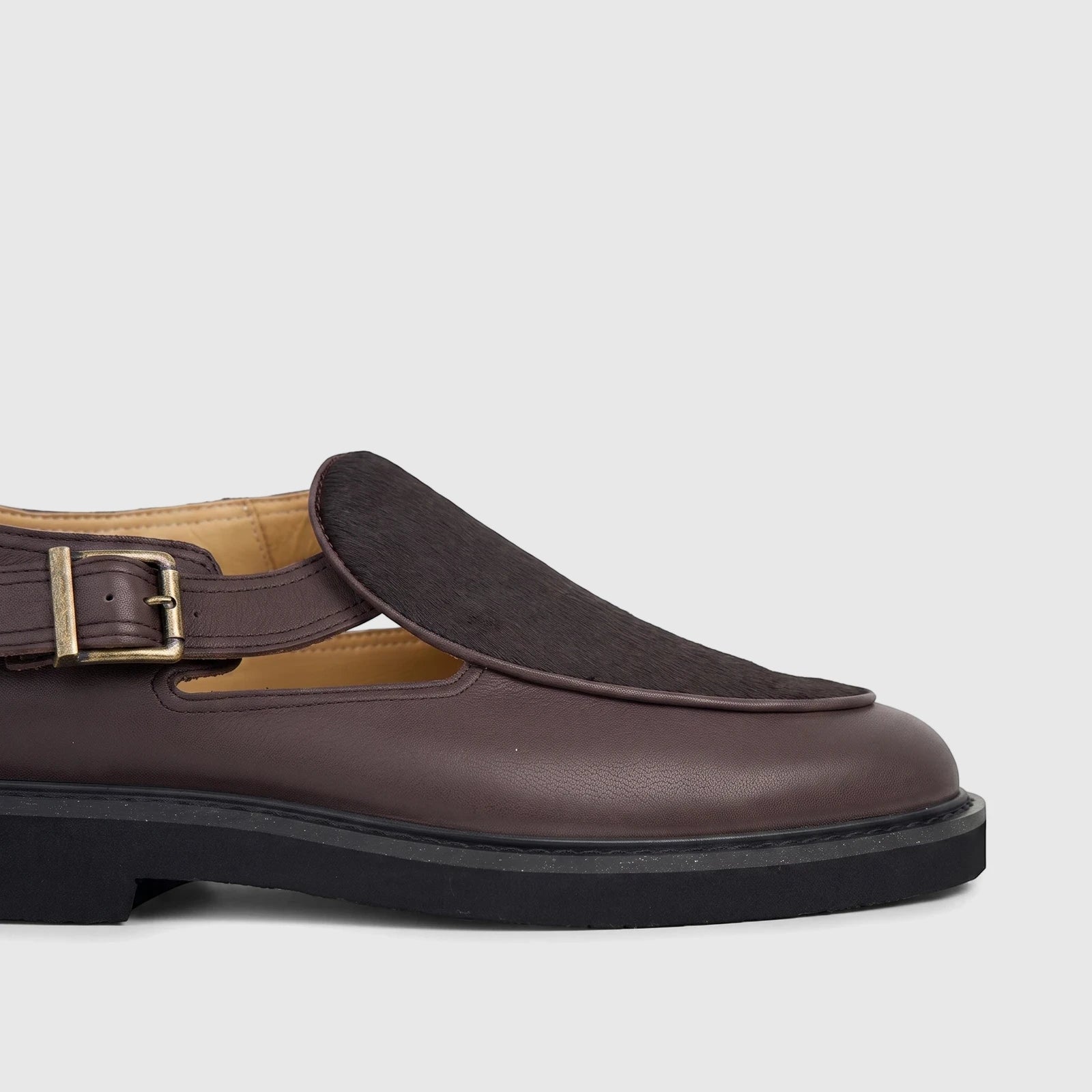 Close-up of a Bulletti Men's Chunky Sole Sandal in stallion brown leather, featuring a dark brown fur-like vamp, buckled