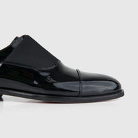 Bulletti Men's Leather Dress Slip On 24-397 black patent leather shoe, side view showing glossy finish and cap toe