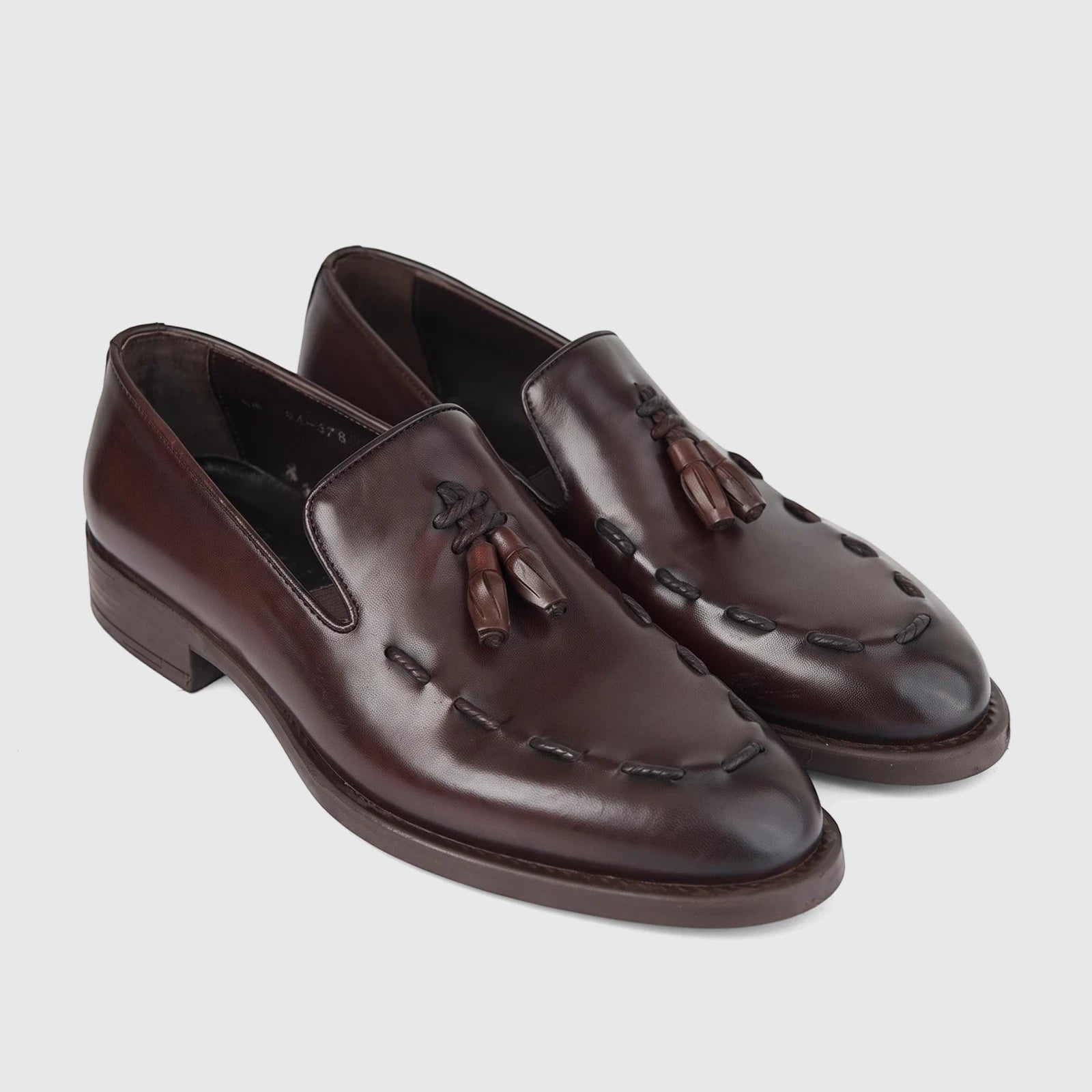 A pair of Bulletti Men's Leather Dress Slip On Shoes with Tassels in rich brown, showcasing the detailed stitching and