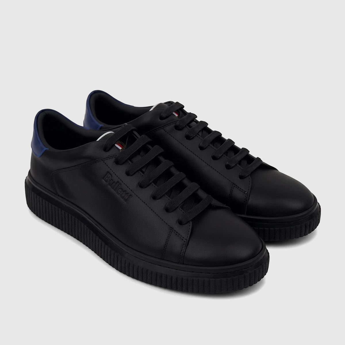 A pair of black Bulletti men's leather sneakers featuring blue heel accents and textured ridged soles, seen from a slightly