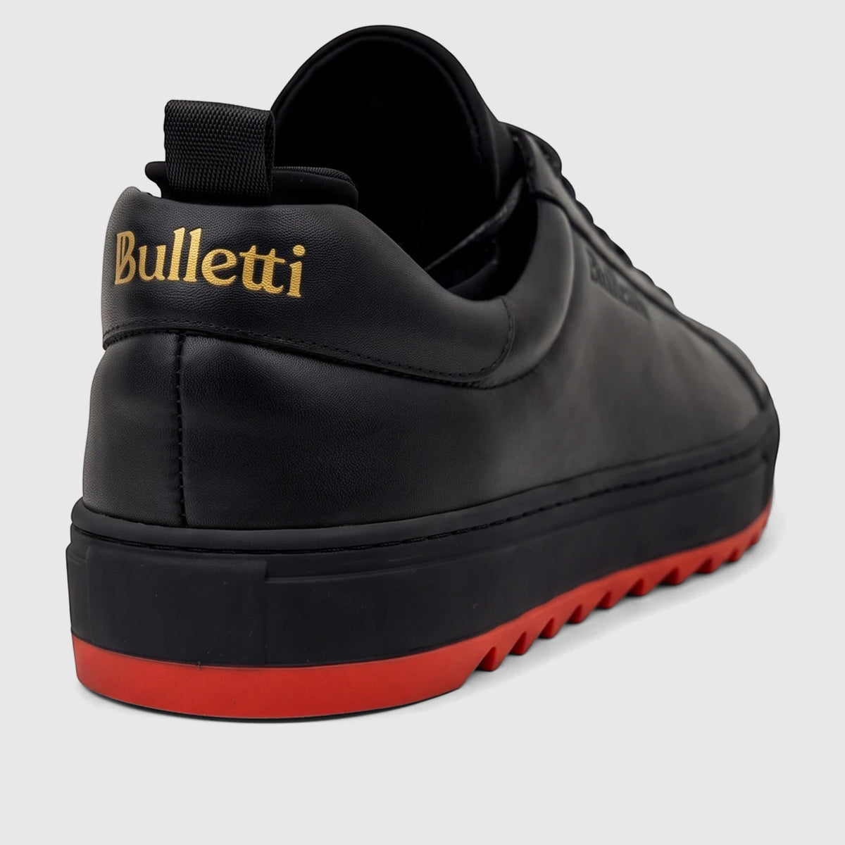 Bulletti Men's Leather Sneaker in black with a distinctive red sole and gold logo detail, viewed from the rear-side angle.