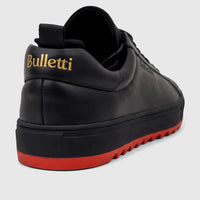 Bulletti Men's Leather Sneaker in black with a distinctive red sole and gold logo detail, viewed from the rear-side angle.