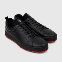 A pair of black Bulletti men's leather sneakers with vibrant red outsoles and black laces, positioned at a slight angle,