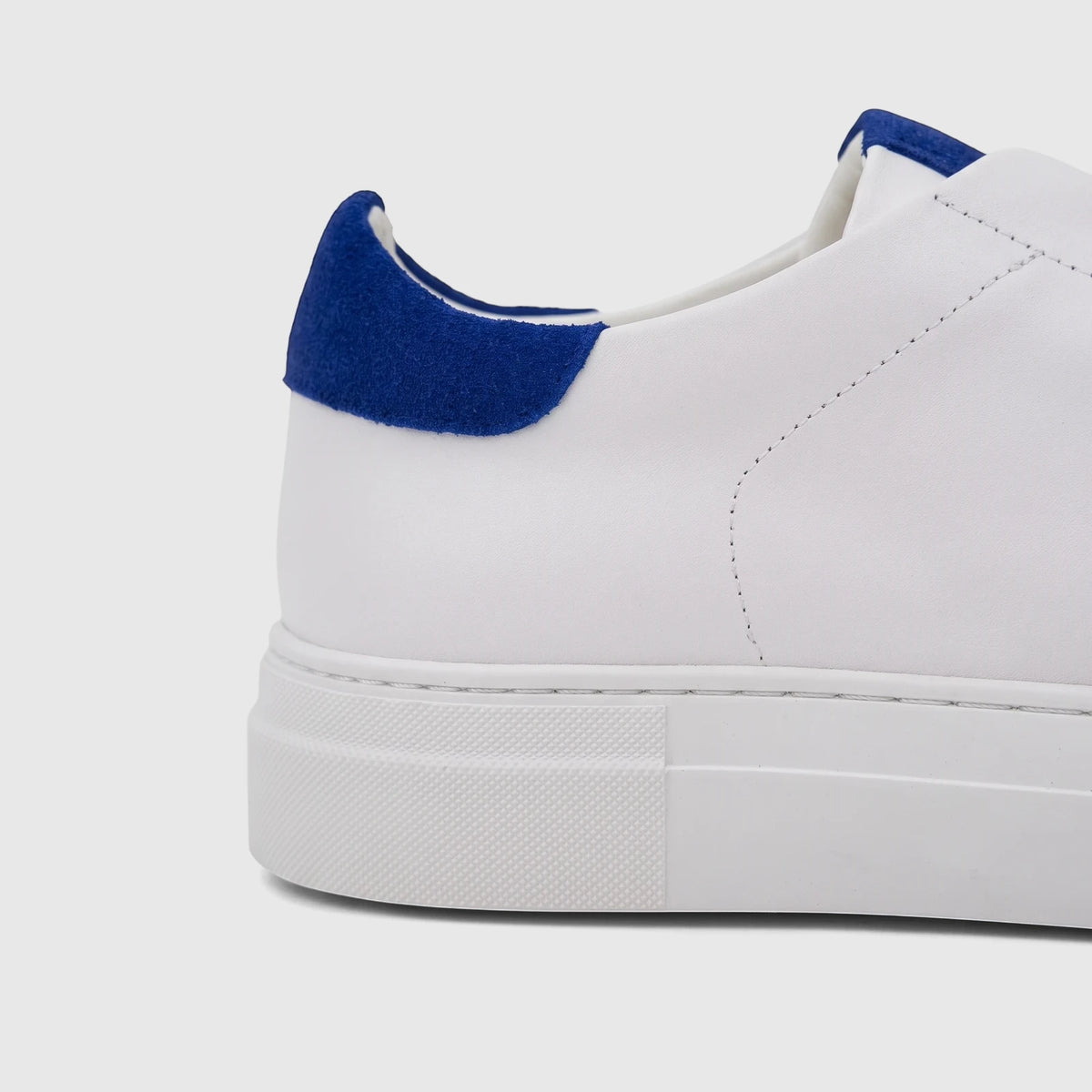 Close-up view of a Bulletti Men's Leather Sneaker in white with a royal blue felt heel accent, showcasing premium materials