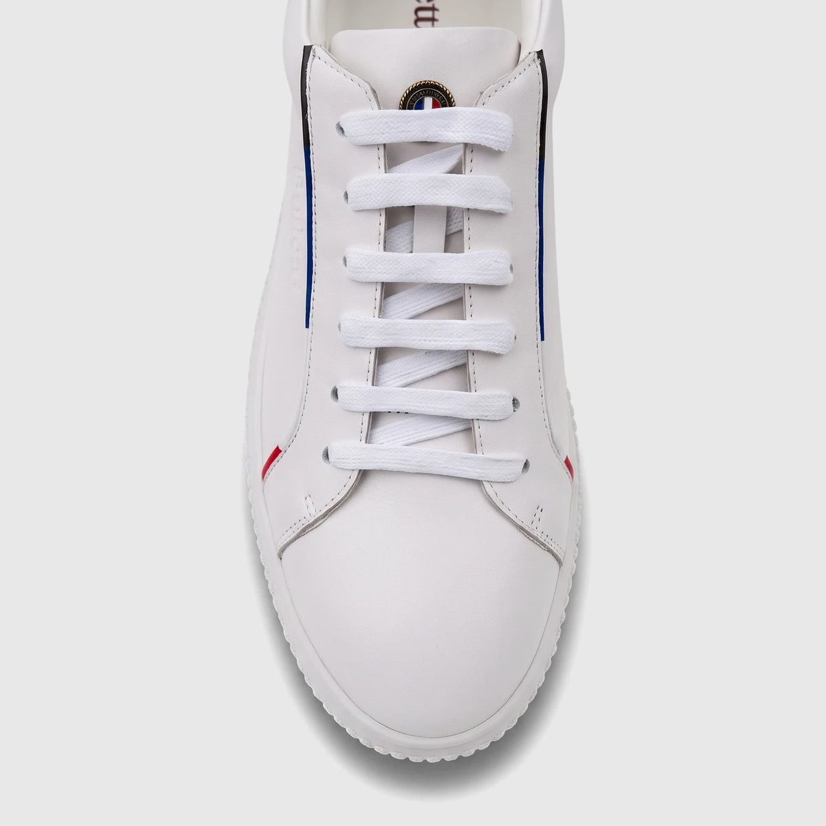 Close-up front view of a white Bulletti men's leather sneaker with white laces and subtle side stripes.