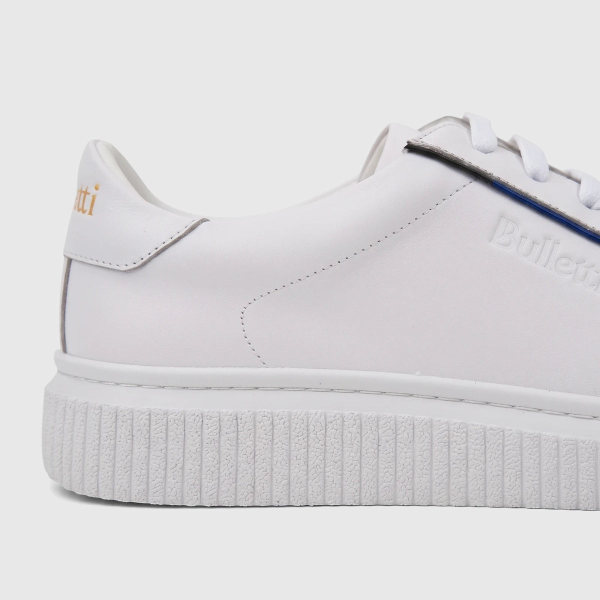White Bulletti men's leather sneaker with white laces and a textured sole, shown in a side profile.