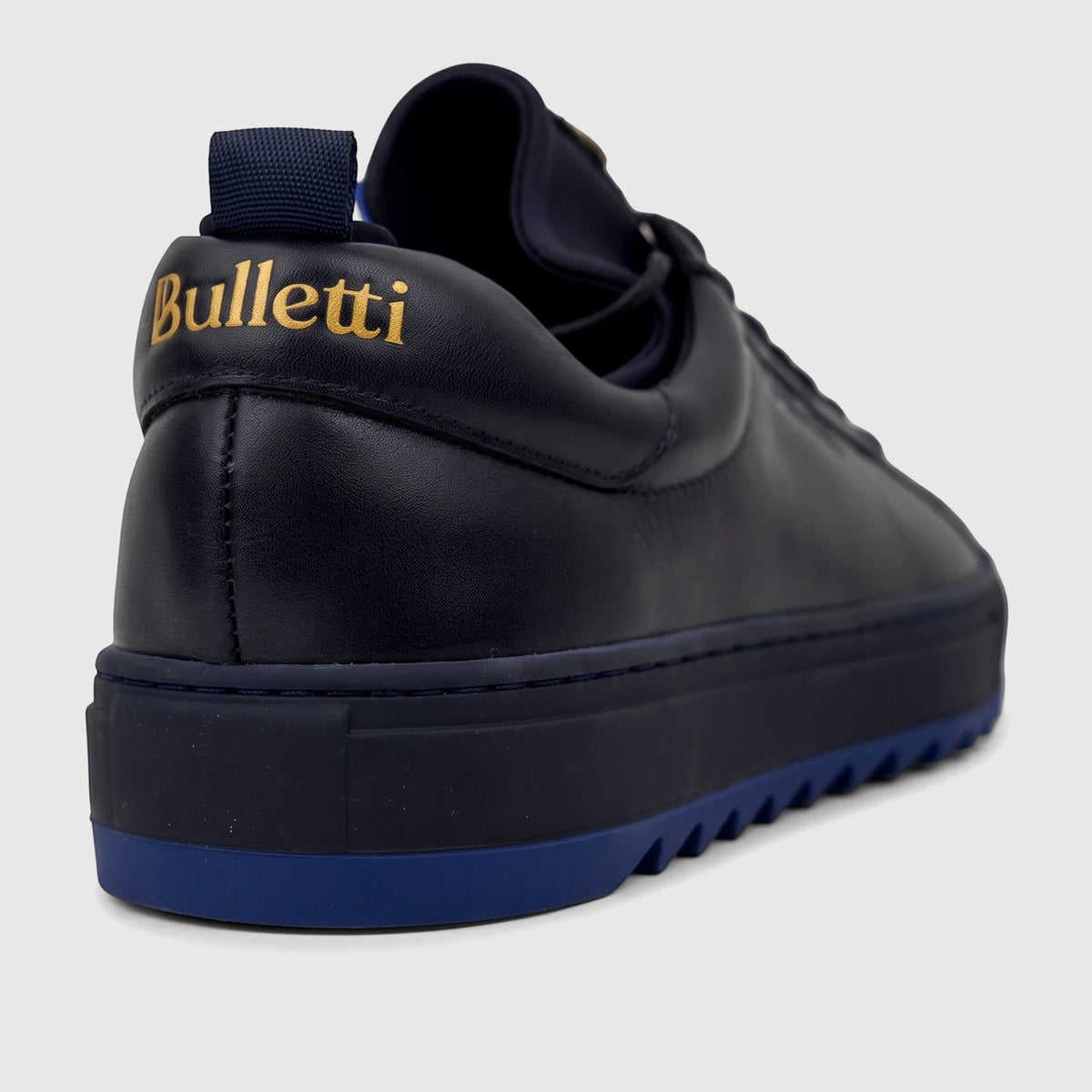 Bulletti men's navy blue leather sneaker, close-up back view with gold logo and blue sole details.